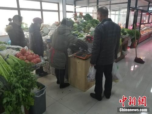 西城区某菜市场内，一名市民使用免费塑料袋买菜。 冷昊阳 摄