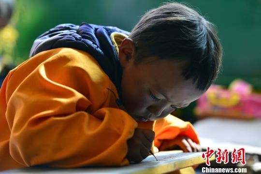 传统的藏文书法练习方式要求练习者盘腿而坐，一手按稳墙星，一手书写。　周文元 摄