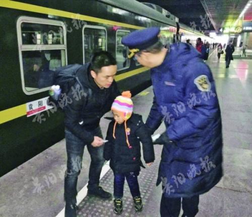 列车工作人员与耿波带着孩子在站台上