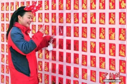 资料图：2018年2月16日，大年初一，游客来到天津方特欢乐世界红包墙前抢包红。<a target='_blank' href='http://www.chinanews.com/'></p>中新社记者 佟郁 摄