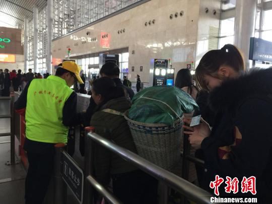 2月26日，长沙南站青年志愿者指导旅客“刷脸”通过自助验票通道。　鲁毅 摄