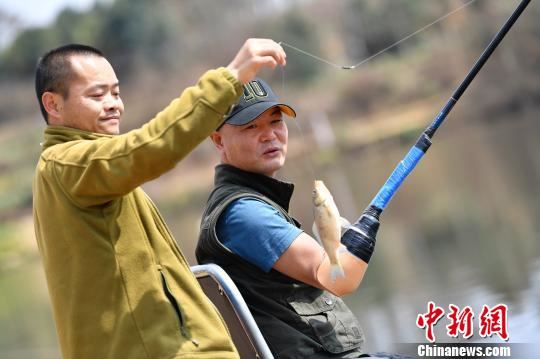 刘帮华钓起一条小鱼，因为身体原因，特别是碰到大鱼的时候都需要表弟协助。　张浪 摄