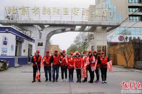 北京市朝阳区实验小学雄安校区，参加“家校警”护学队的当地家长志愿者在校门口。
