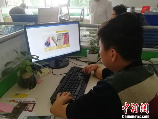 4月28日，在江西省宁都县电商园103室，美编在设计图片。　苏路程 摄