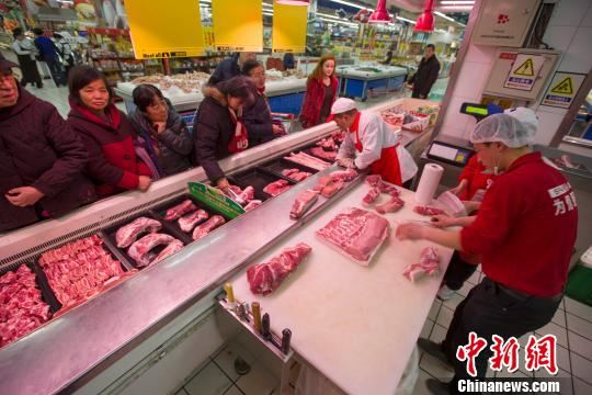 山西太原，超市员工在为民众分解猪肉。张云 摄