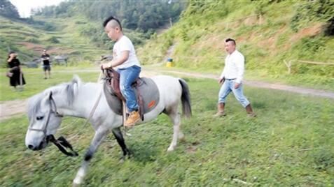 黄金星在牧场教儿子骑马。 本报记者 邹飞 摄