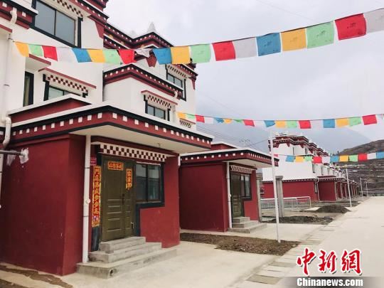 坪垭藏族乡腰道村藏红色与白色相间的“小二楼”整齐排列，五彩经幡随风摇曳。　艾庆龙 摄